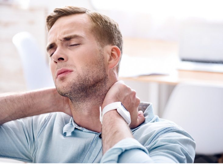 Man holding the back of his neck in discomfort.